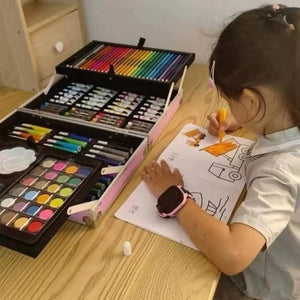 Enfant qui dessine à côté de la mallette de coloriage ouverte sur ses trois niveaux