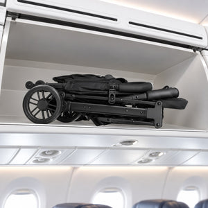 Poussette pliée rangée dans le coffre à bagages d'un avion