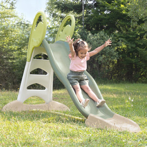 Enfant bras levés sur le toboggan Smoby XL installé sur une pelouse