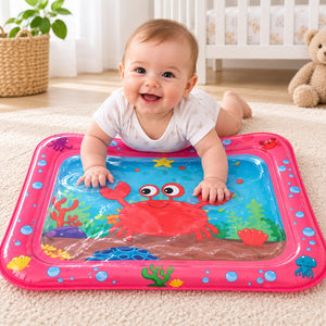 Bébé sur le ventre jouant sur le tapis d'eau gonflable crabe à contour rose