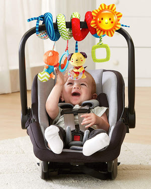Bébé jouant avec la spirale VTech accrochée sur l'anse d'un siège auto