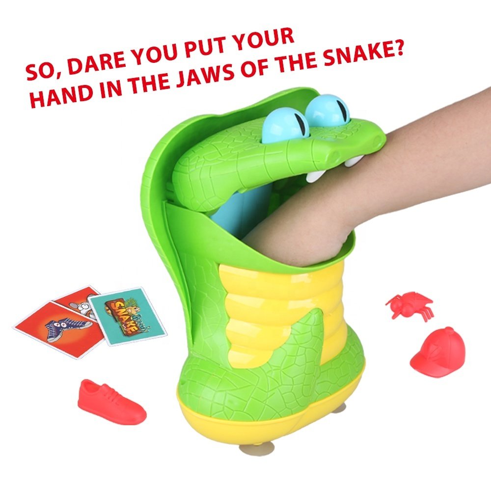 Main d'enfant qui retire un objet de la gueule du Greedy Snake