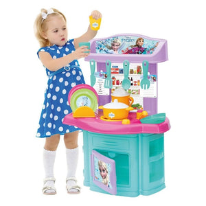 Petite fille jouant avec la cuisine Frozen Dede et sa vaisselle