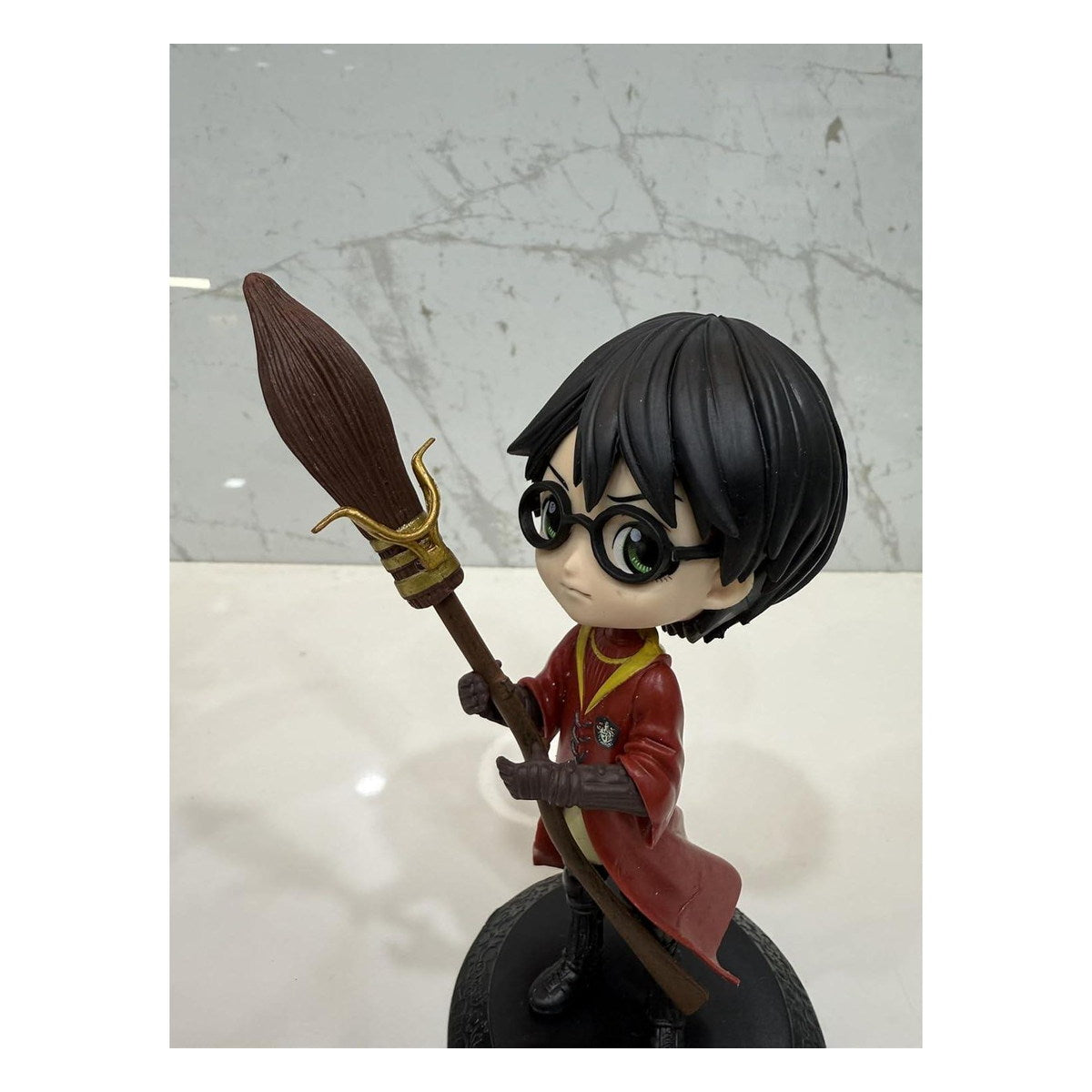 Figurine chibi de Harry Potter en tenue de Quidditch rouge avec son balai