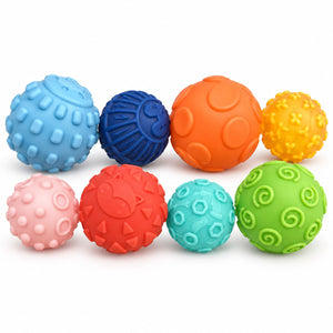 Les 8 balles sensorielles texturées HUANGER : bleu à pavés, marine nervurée, orange à pois, jaune à picots, rose à cercles, rouge à triangles, turquoise à hexagones et verte à spirales