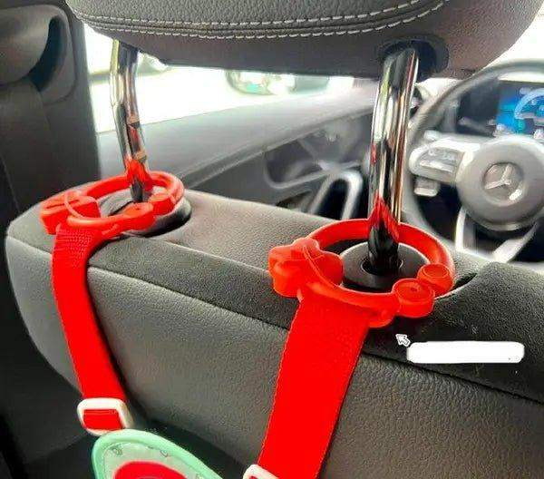 Les deux crochets rouges et les sangles du volant fixés sur l'appuie-tête du siège avant