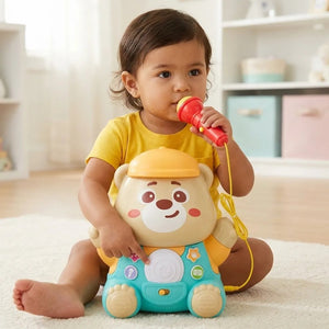 Jeune enfant assis avec l'ours karaoké et son micro