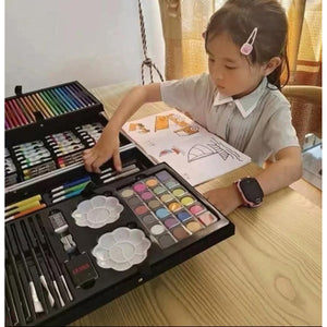Fillette choisissant une couleur dans la mallette de coloriage dépliée sur une table