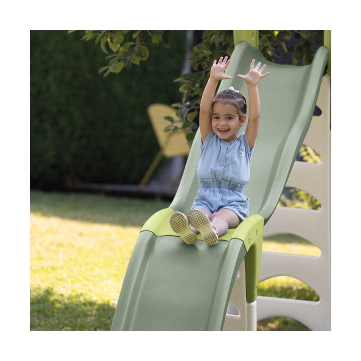 Enfant qui descend le toboggan Smoby Super Megagliss dans un jardin