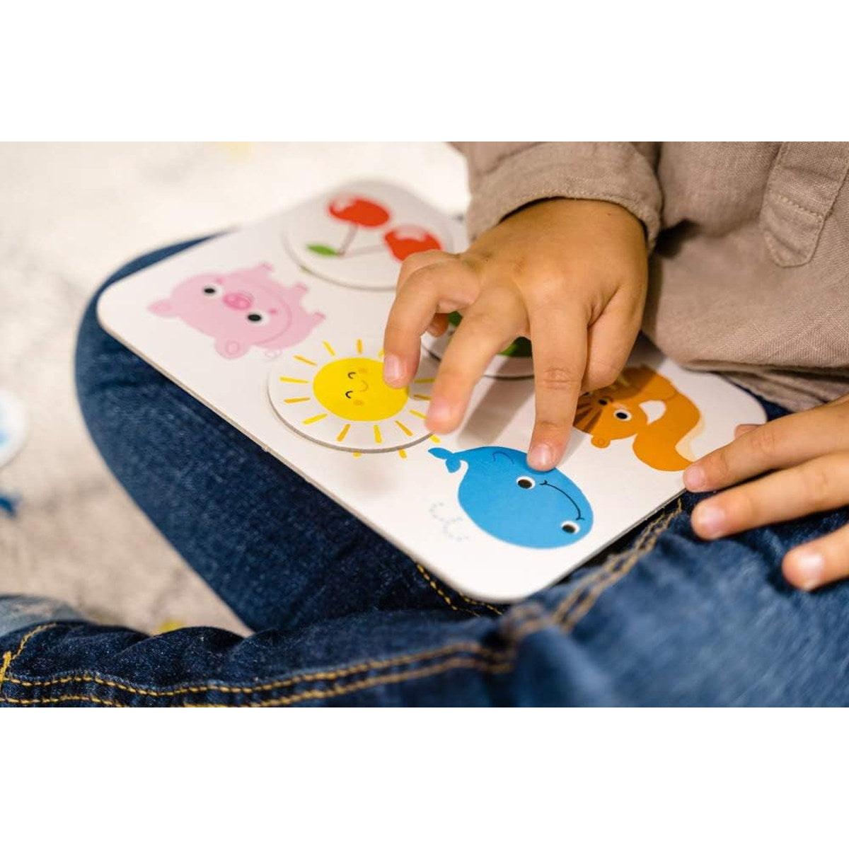 Enfant qui pose un jeton sur une planche Nathan Couleurs et formes