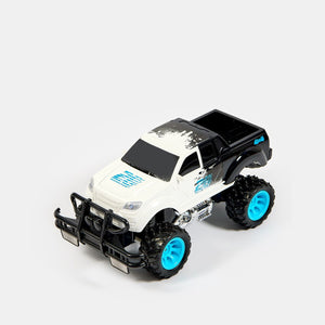Monster truck radiocommandé blanc vu de profil, jantes bleu turquoise et pneus crantés
