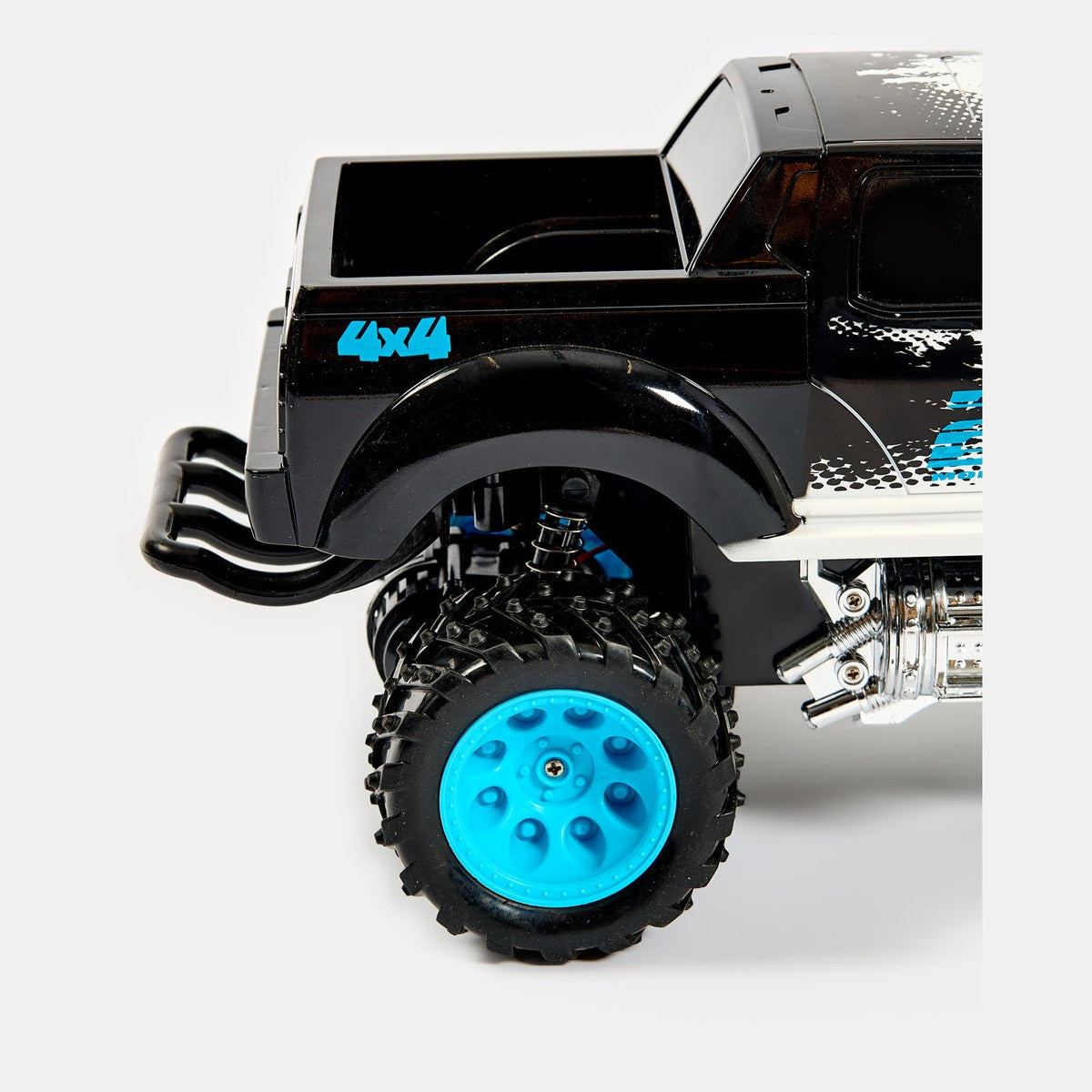 Détail de l'amortisseur à ressort et du pneu cranté du monster truck RC Wild Monster