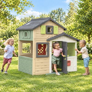 Trois enfants jouant ensemble dans et autour de la maisonnette Smoby Friends House Evo'