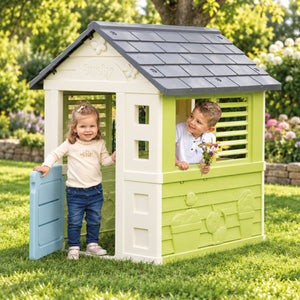 Deux enfants jouent ensemble dans la maisonnette de jardin Smoby Jolie
