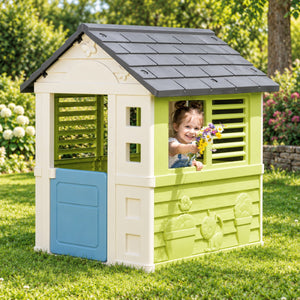 Enfant jouant avec des fleurs devant la cabane de jardin Smoby Jolie