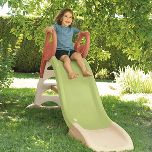 Enfant assis en haut du toboggan Smoby KS, mains sur les rampes
