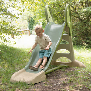 Enfant qui descend la piste du toboggan Smoby XL dans un jardin