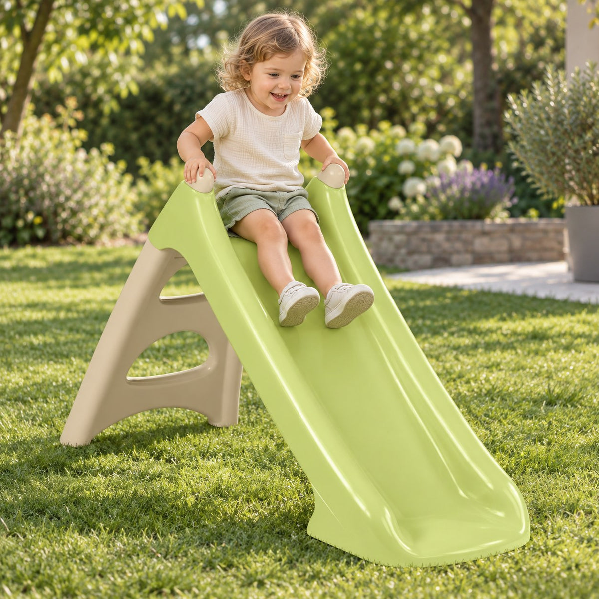 Enfant qui glisse sur le toboggan Smoby XS dans un jardin