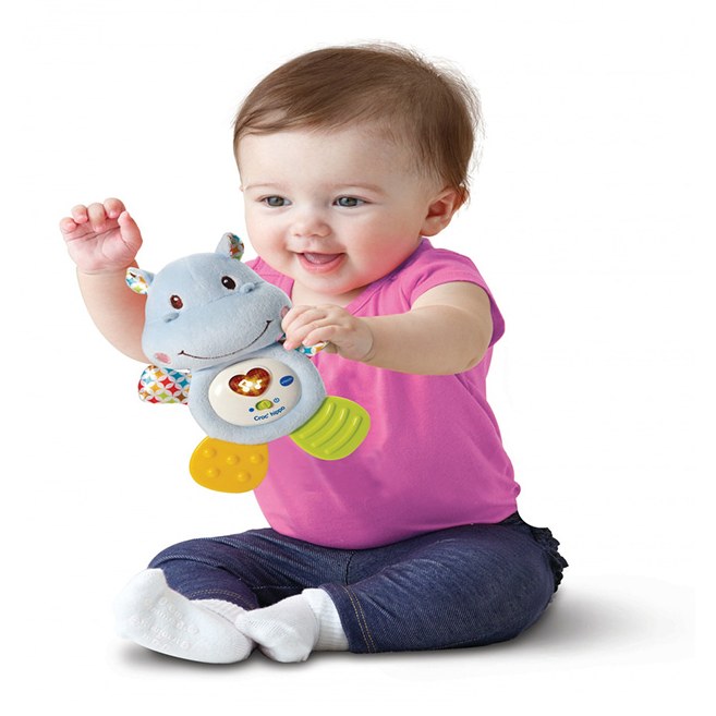 Bébé tenant le Croc'hippo VTech et appuyant sur le bouton cœur