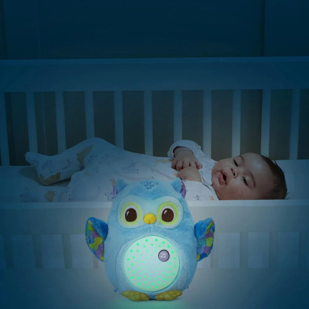 Veilleuse Lumi chouette bleu allumée dans le lit d'un bébé endormi