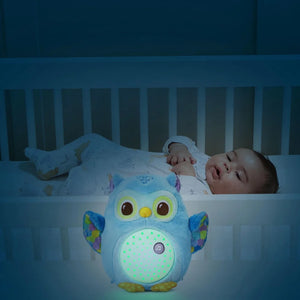 Veilleuse Lumi chouette bleu allumée dans le lit d'un bébé endormi