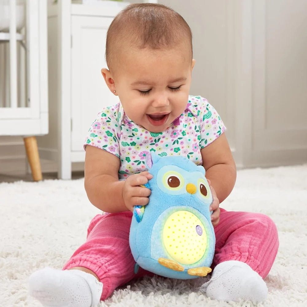 Bébé assis jouant avec la veilleuse Lumi chouette bleu illuminée