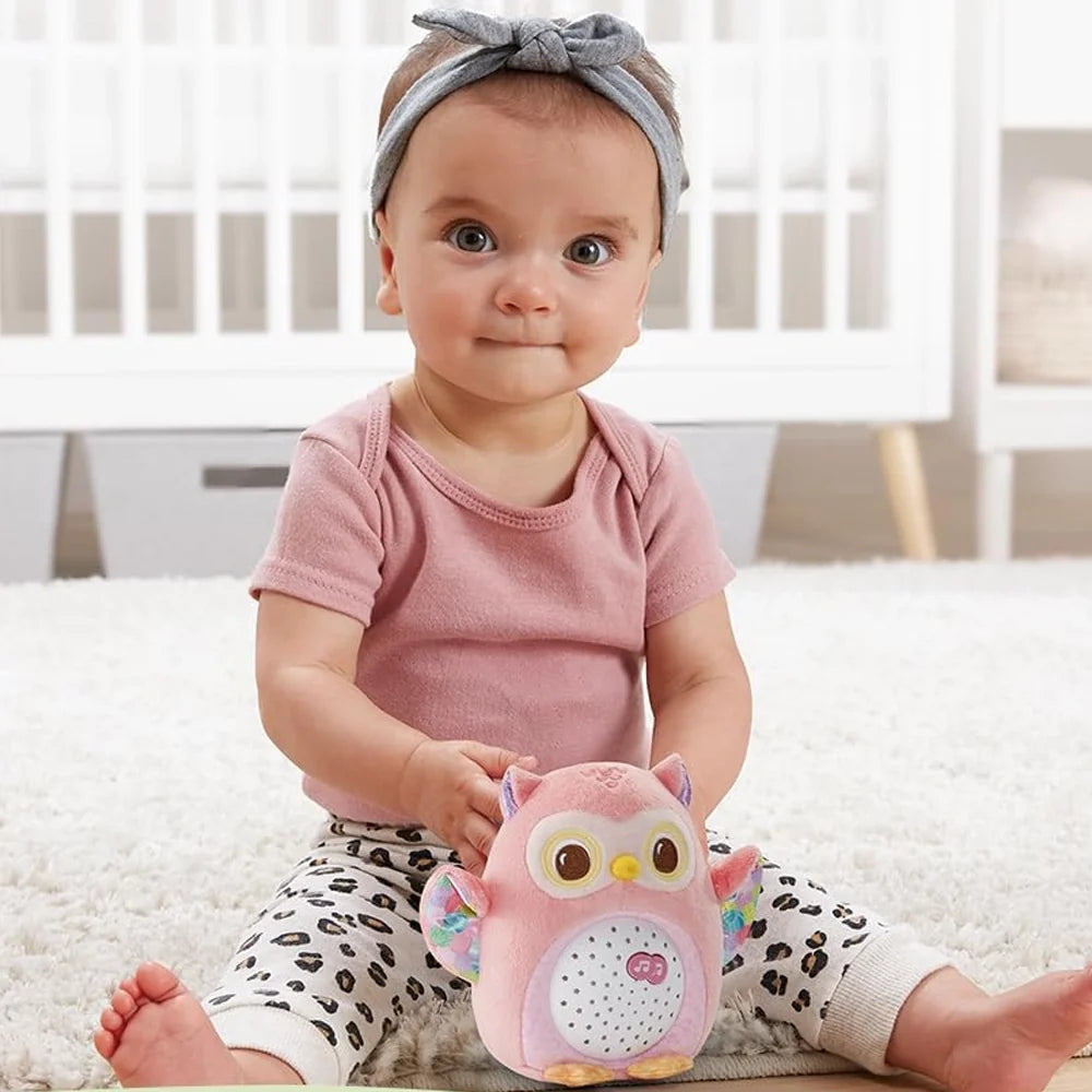 Petite fille assise avec la peluche Lumi chouette rose VTech