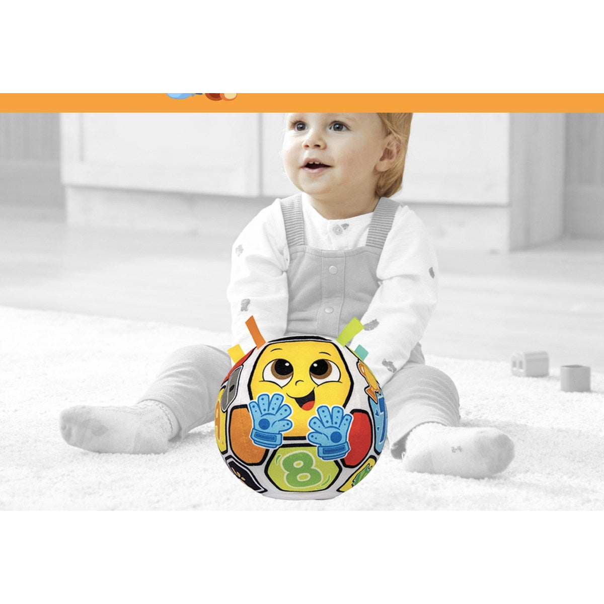 Bébé assis sur un tapis à côté du ballon musical Winfun Playtime Buddy